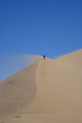 man walking in the sand dunes