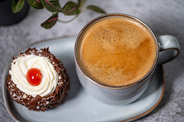 Coffee and baked pastry breakfast. Fresh baking treat, A cup of coffee and a cookie on a plate set against a marble background
