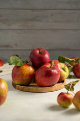 Freshly picked red apple in a wooden plate, bright rustic background