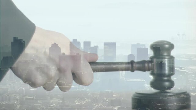Judge's hand holding gavel swinging down to strike block against faint skyline signaling verdict
