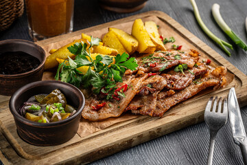 Grilled pork with potatoes and pickles.