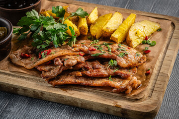 Grilled pork slices with baked potatoes.