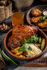 Roasted pork knuckle with potatoes and sauerkraut.