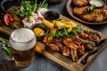 Grilled meat platter with vegetables and beer.