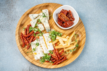 Cheese platter with salami and sun-dried tomatoes.
