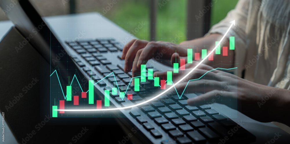 Poster a close-up view of hands typing on a laptop keyboard, accompanied by a digital financial graph overl