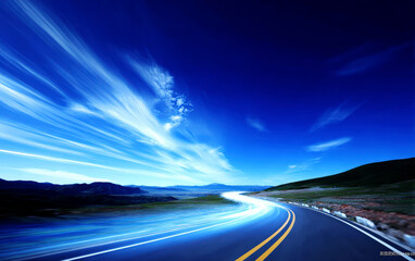 A scenic road under a clear blue sky with light trails