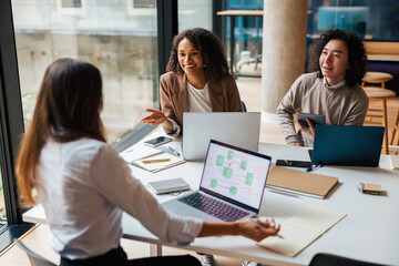 A diverse and dynamic group of individuals engages in a highly productive meeting within a modern office setting