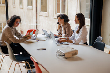 Obraz premium In a modern workspace, three skilled professionals come together to collaborate on projects and share innovative ideas