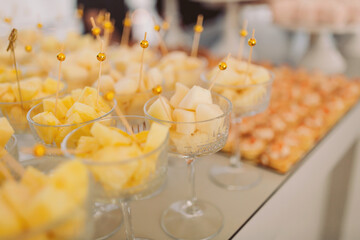Delightful fruit treats and elegant desserts displayed at a vibrant summer gathering in a sunlit venue