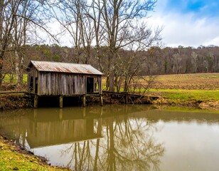 Rustic wooden shed by a pond on a cloudy day