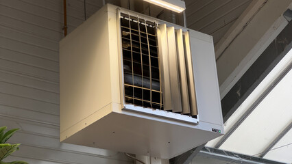 A large, white industrial HVAC unit mounted on the wall of a commercial building