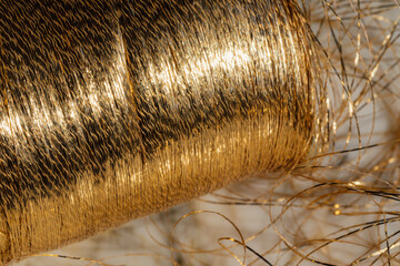 unraveling spool of golden thread