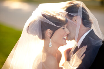 Romantic Bride and Groom Laughing Together Behind Wedding Veil Outside - Romantic Moment 