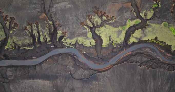 Fiji, Tana Island: Aerial drone footage revealing a sinuous river winding through the striking volcanic landscape of Port Resolution. Wild nature travel landscape. Top down flight