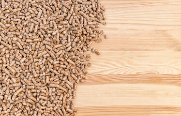 Biomass flat lay with bulk wood pellets on wooden background and copy space.