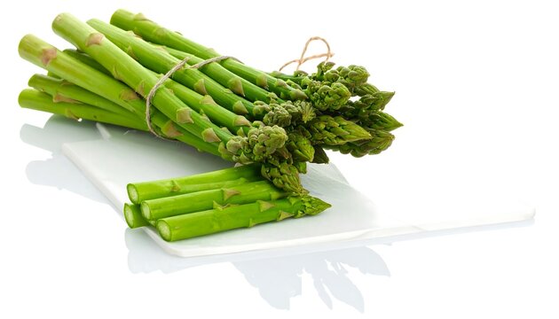 Fresh green asparagus tied with twine on a white plate - Powered by Adobe