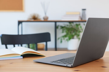 Home workspace. Modern laptop and stationery on wooden desk indoors, closeup