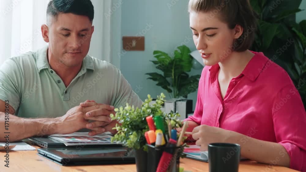 Poster professional happy interior designer looking at tablet while project manager choosing color palettes
