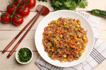 Tasty fried rice, products and chopsticks on light wooden table, flat lay