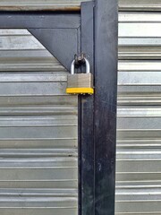 Metal padlock on iron gate for security and protection