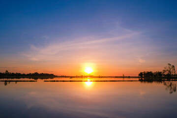 Beautiful sunset over a calm lake with reflection of colorful sky.