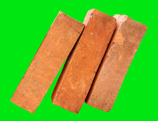 Side view of three cracked old red or orange bricks in stack isolated on green background with clipping path