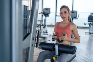 Woman engages in focused workout at modern gym, showcasing her commitment to fitness and self care. This exercise routine promotes wellness and enhances overall health