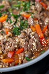 Close up of Healthy One Pot Meal of Ground Bison, Mushrooms, Broccoli, Barley, and Quinoa with Fresh Herbs