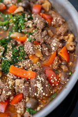 Close up of Healthy One Pot Meal of Ground Bison, Mushrooms, Broccoli, Barley, and Quinoa with Fresh Herbs
