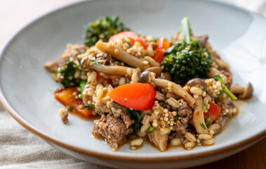 Close up of Healthy One Pot Meal of Ground Bison, Mushrooms, Broccoli, Barley, and Quinoa with Fresh Herbs