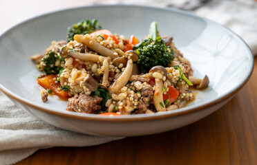 Close up of Healthy One Pot Meal of Ground Bison, Mushrooms, Broccoli, Barley, and Quinoa with Fresh Herbs