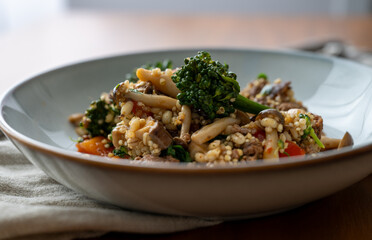 Close up of Healthy One Pot Meal of Ground Bison, Mushrooms, Broccoli, Barley, and Quinoa with Fresh Herbs