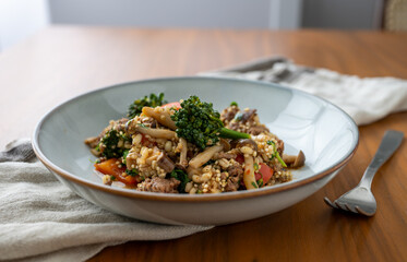 Close up of Healthy One Pot Meal of Ground Bison, Mushrooms, Broccoli, Barley, and Quinoa with Fresh Herbs