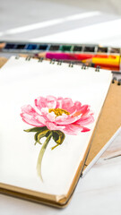 Delicate Pink Bloom Sketch on Notepad Under Soft Studio Light