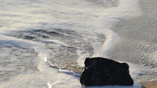 a rock in the morning swell, at a Far North Queensland beach, Australia