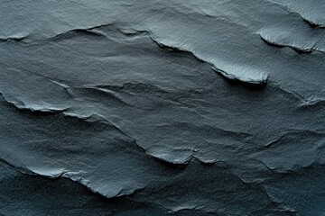 close-up of layered rough dark gray stone texture showing uneven surfaces and jagged edges