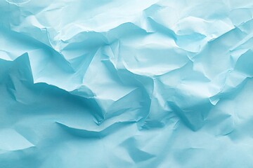 Obraz premium Close-up of crumpled light blue paper showing various folds and creases creating abstract texture and shadows