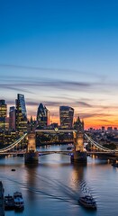 Fototapeta premium A captivating view of Tower Bridge over the Thames River at sunset, highlighting the illuminated cityscape of London.