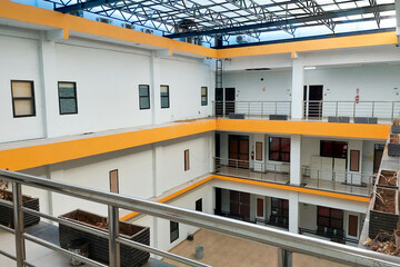 Interior courtyard of a simple multi-story building with white walls and bright yellow accents