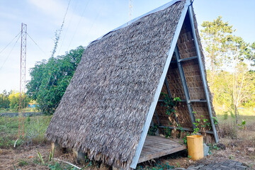 Traditional open-sided hut with an A-frame structure and a palm leaf thatched roof.