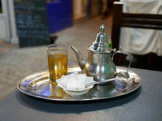 モロッコのエッサウィラのレストランのミントティー（モロッコグラスとティーポットと砂糖）