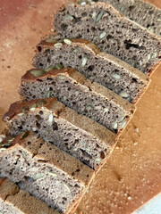 Sliced dark bread topped with pumpkin seeds.