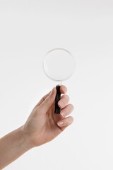 hand holding magnifying glass