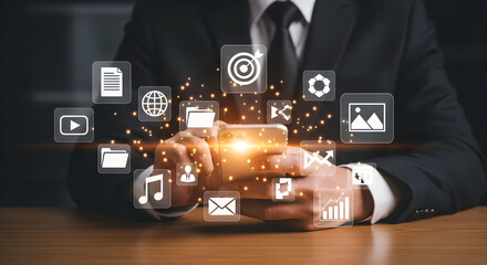 Businessman using smartphone with floating digital icons representing technology communication social media and data management in modern office setting