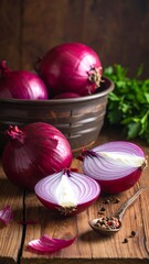 Vibrant red onions, whole and sliced, rest on a rustic wooden surface, alongside a small bowl and a spoon of peppercorns.