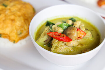 A Culinary Delight: Savory Thai Green Curry with an Egg Omelette: Experience the aromatic allure of a vibrant Thai green curry served alongside a fluffy egg omelette.