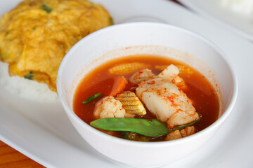 Exquisite Culinary Delights: A vibrant array of flavorful dishes, comprising a rich, savory soup with fresh vegetables, tender fish, alongside an omelette, arranged on a pristine plate.
