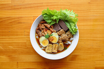 Delicious Asian Cuisine: A vibrant overhead shot of an appetizing dish, expertly arranged with savory meats, fresh greens, and boiled eggs, all nestled on a pristine plate.