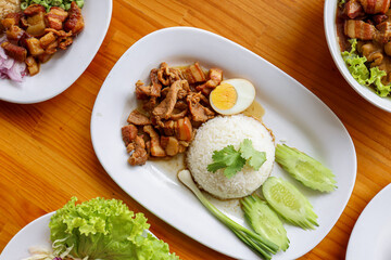 Delicious Cuisine Display: A culinary masterpiece is presented on a pristine white plate, showcasing an artful arrangement of perfectly cooked meat, fluffy rice, a delicate egg, and fresh vegetables.
